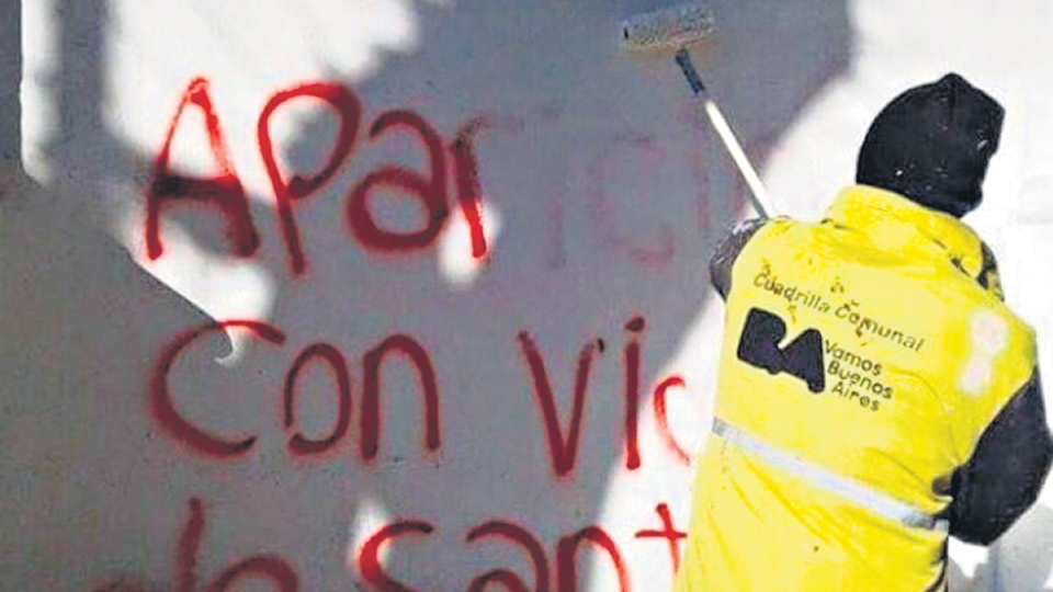 Un trabajador de la ciudad limpia pintadas que piden por la aparición de Santiago Maldonado.