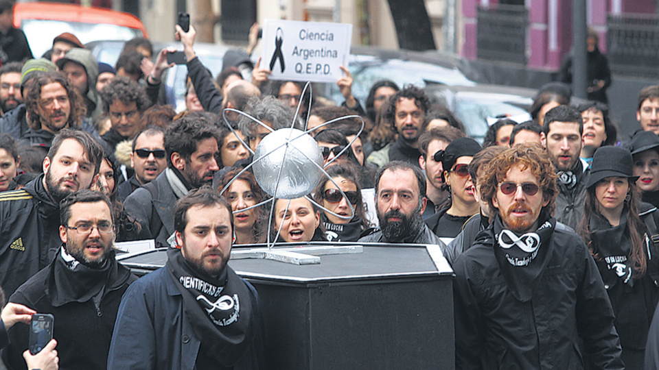 Becarios e investigadores hicieron una procesión vestidos de luto, frente al Polo Científico.