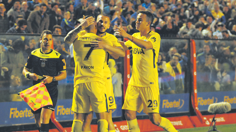 Pavón, de espaldas, recibe el abrazo de Benedetto por su gol, mientras Jara se suma al festejo.
