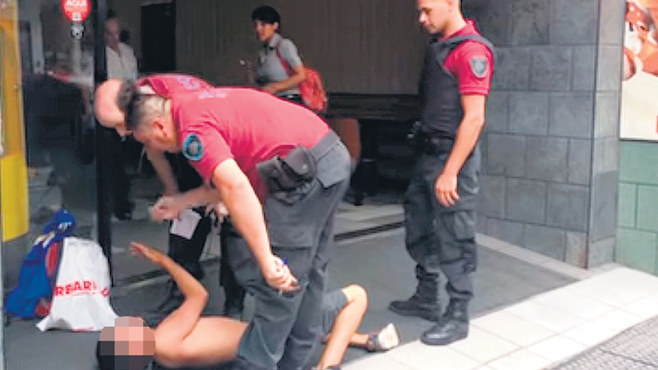El excedido de cuerpo prepotea al adolescente que llora pidiendo clemencia.