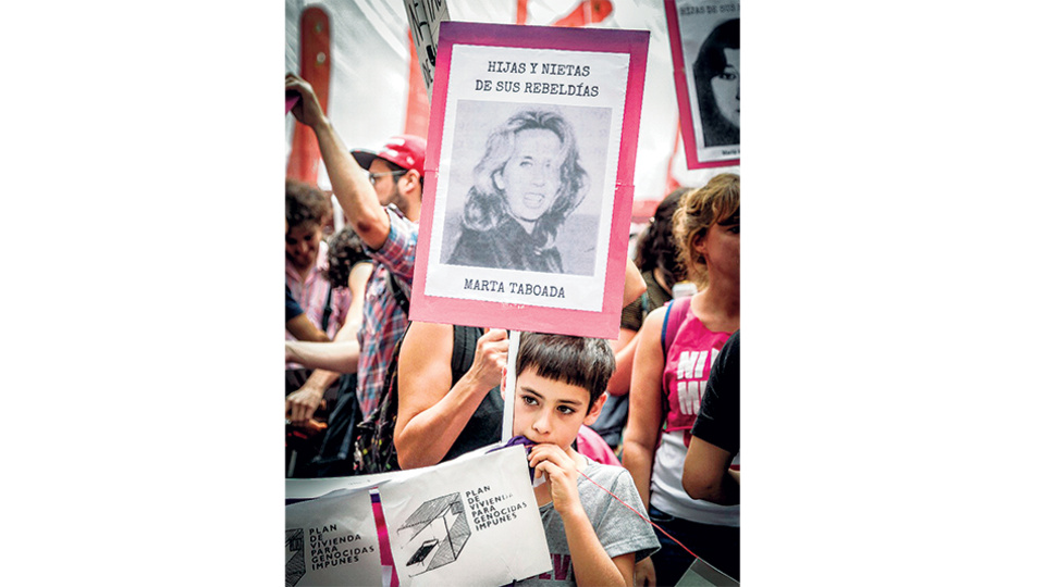 En la columna de Ni Una Menos, un niño lleva la imagen de su abuela. En la pancarta, la leyenda “Hijas y nietas de sus rebeldías”.