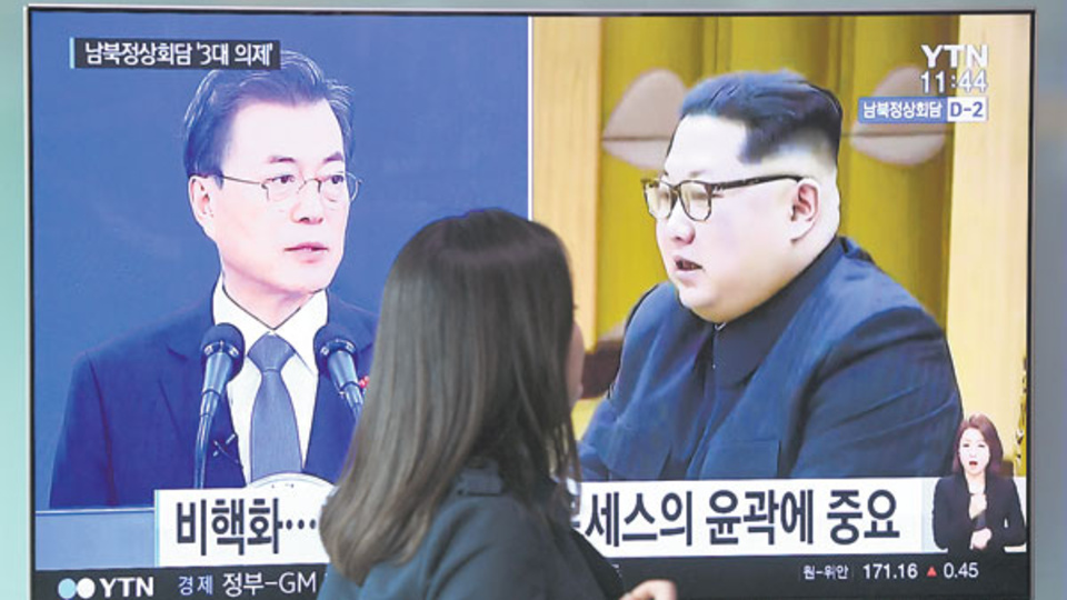 Moon y Kim aparecen en la pantalla de televisión ayer en una estación de subte de Seúl.