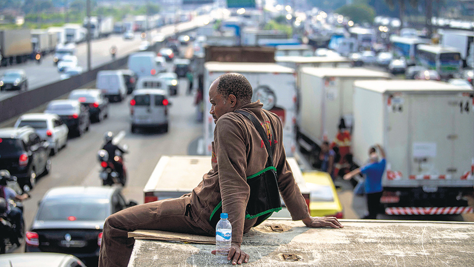 Un camionero observa el bloqueo de una autopista en la entrada a Río de Janeiro, donde ya se siente el desabastecimiento de insumos básicos.