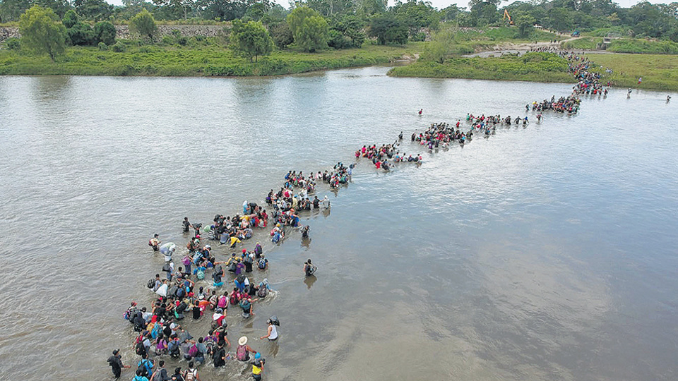 Migrantes salvadoreños cruzan el río Suchiate en México camino a la frontera con EE.UU.