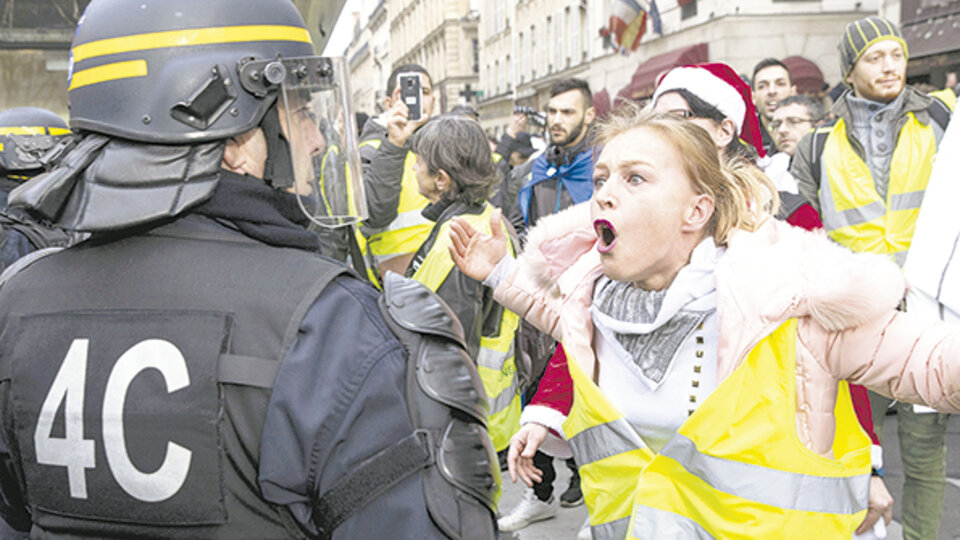 Una manifestante le gritaba a un policía durante la protesta de ayer en París.