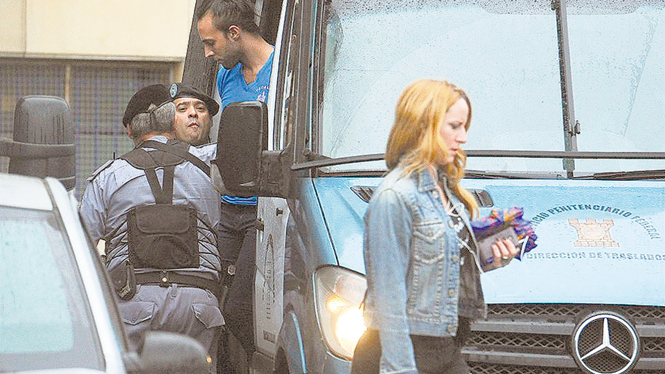 Giselle Robles y detrás, bajando de un vehÃculo del Servicio Penitenciario, Leonardo Fariña.