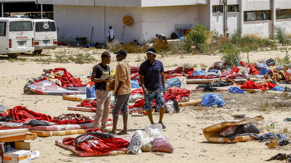 Migrantes caminan cerca del complejo penitenciario de Tajura después del bombardeo.
