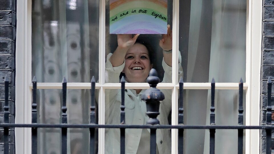 Una mujer muestra el arcoiris que se ve en las ventanas por estos días de encierro; este aparece desde la residencia oficial del primer ministro. 