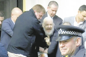 Assange es arrastrado por policías a un patrullero en la entrada de la embajada de Ecuador.