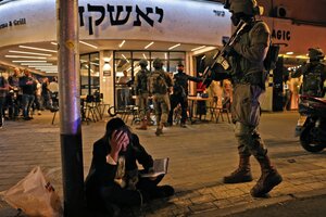Un judío ortodoxo lee el Libro de Salmos en lugar del atentado. Foto 2: peritos forenses procesan una escena del tiroteo. (EFE) (Fuente: AFP)