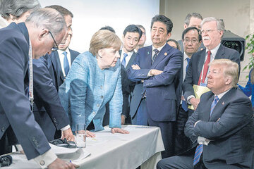 Trump sentado, los demás líderes del G7 parados y una Merkel desafiante que parece increparlo en Charlevoix.