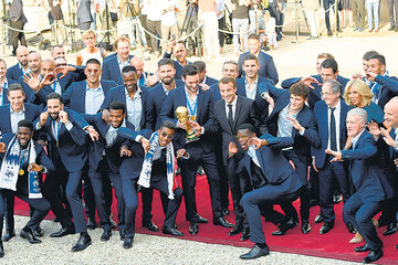 Los jugadores de Francia muestran la Copa y sus medallas junto al presidente Macron. (Fuente: AFP)