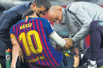 Messi en el piso, atendido por los médicos, que confirmaron la fractura tras el partido.