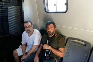 Bernardino Ávila (izquierda) detenido en un celular, junto a otro colega.