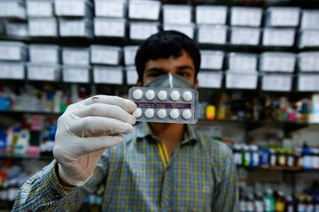 Un e,pleado de una farmacia de Nueva Delhi muestra una tira de pastillas de hidroxicloroquina. (Fuente: AFP)