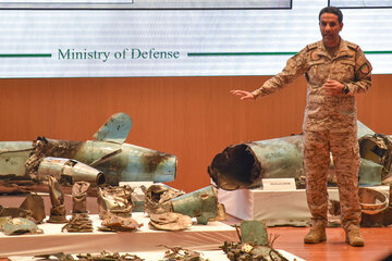 Un oficial del ejército saudí muestra restos de drones y misiles usados en el ataque a la refinería. (Fuente: AFP)