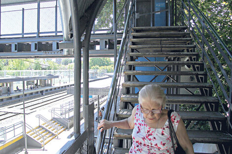 Una mujer se esfuerza para bajar la escalera del puente y llegar al anden a tomar el tren. (Fuente: Archivo)