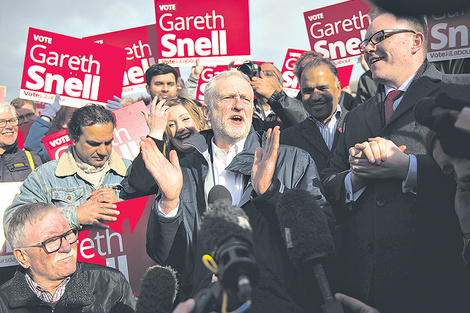 Corbyn (centro) festeja en Stoke, centro de Inglaterra, el triunfo del laborista Gareth Snell (der.) (Fuente: AFP)