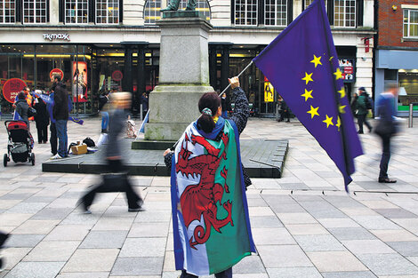 Una manifestante protesta contra la puesta en marcha del Brexit con las banderas de la UE y de Gales. 