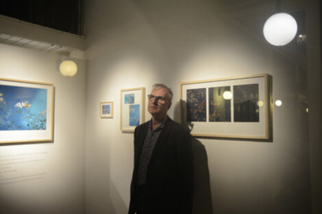 Alejandro Lamas junto a algunas de sus fotografías, durante la inauguración. (Fuente: Sebastián Joel Vargas)