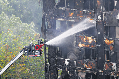 Una manguera automática echa agua dentro del edificio calcinado anteayer en Londres. (Fuente: AFP)