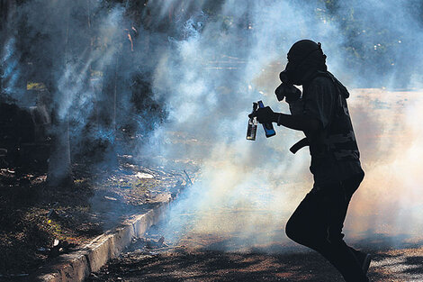 Un manifestante corre entre el gas lacrimógeno durante una marcha en Barquisimeto.