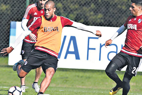 n Jonatan Maidana le pega a la pelota en el entrenamiento de ayer, mientras Enzo Pérez intenta controlarlo. (Fuente: Prensa River)