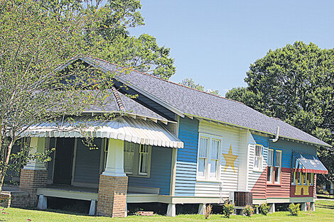 Una casa tradicional pintada con los colores de la bandera de los antiguos acadianos.