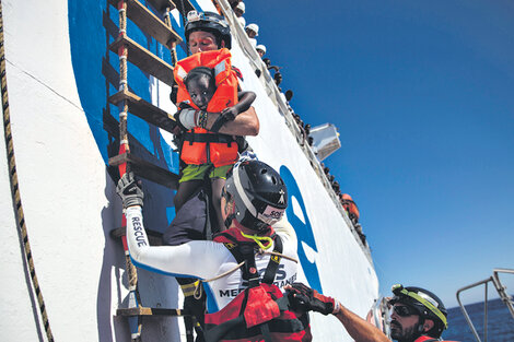 Voluntarios sostienen a una niña rescatada a 20 kilómetros de la costa de Libia. (Fuente: AFP)