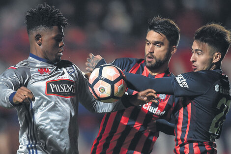 Rojas y Caruzzo intentan frenar a De Jesús.