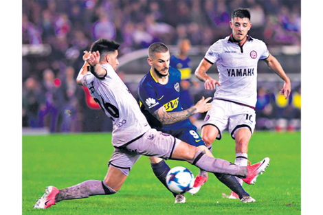 n Darío Benedetto maniobra ante la doble marca de Di Plácido y Rojas. El de Boca terminó definiendo el partido cerca del final. (Fuente: Télam)