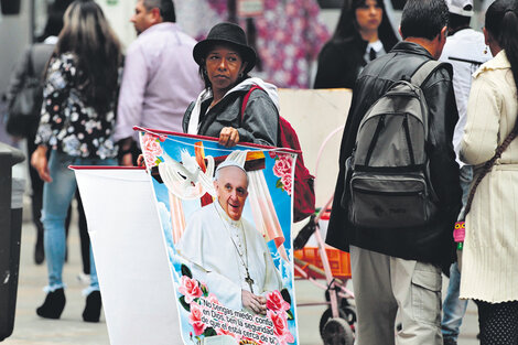 Una mujer vende afiches con la cara del Papa ayer cerca de la catedral de Bogotá.