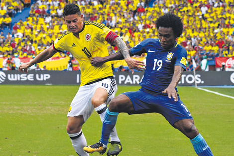 El colombiano James Rodríguez lucha por la pelota con el brasileño William.