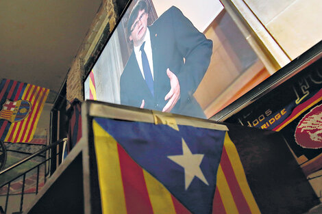 La pantalla gigante de un bar de Barcelona muestra la imagen de Puigdemont dando un mensaje a los catalanes. (Fuente: AFP)