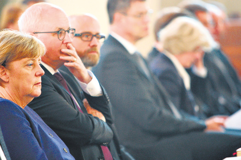 Merkel junto a congresistas de diferentes partidos, en el funeral de un político conservador ayer en Berlín. (Fuente: EFE)