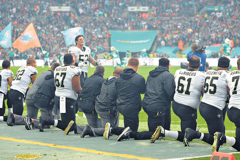 Deportistas de la NFL se arrodillan en el campo de juego durante la entonación del himno.