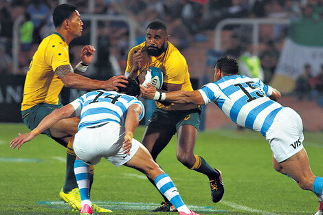 Koroibete, capitán de los Wallabies, lleva la pelota ante Moroni y Tuculet.