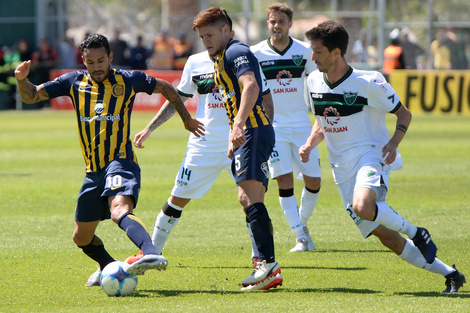 Colman y Gil, peleando en el medio sanjuanino. El Canaya se complicó solo ante un rival débil. (Fuente: Télam)