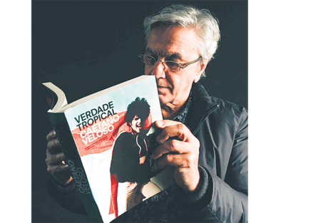 El autor leyendo la flamante edición conmemorativa 20 años de su libro. En la nueva tapa, una foto suya de 1968, luciendo el Parangolé P4 Capa 1, 1964, de Helio Oiticica.