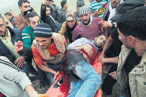 Manifestantes palestinos transportaban el cuerpo sin vida de Mohammed Muheisen ayer en Gaza.