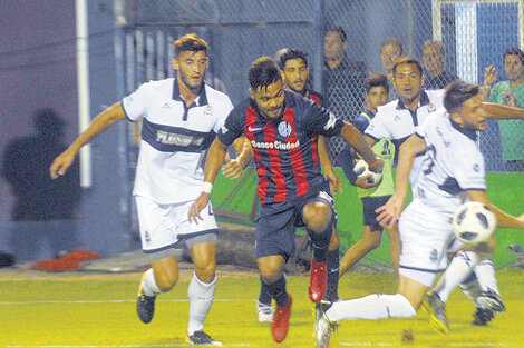 Gudiño intenta avanzar, cercado por hombres de Gimnasia. (Fuente: Télam)