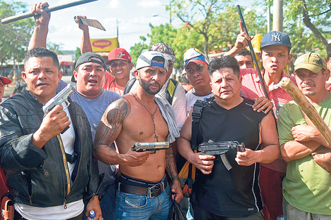 Los dueños de un supermercado de Managua protegen con sus armas su negocio de los saqueos.