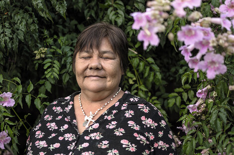 La mujer con vestido estampado y flores de su jardín.