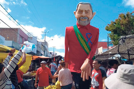 Seguidores del PT pasean un muñeco de Lula en una favela.