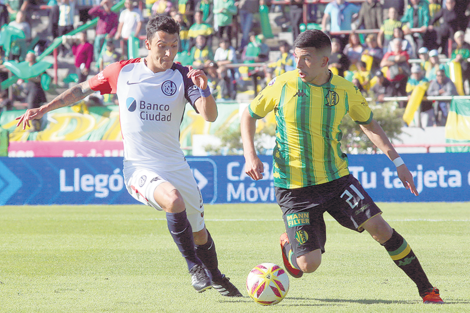 Emanuel Iñiguez lleva la pelota ante la presión de Botta.