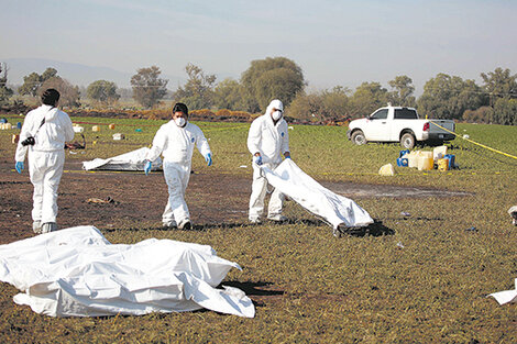 Expertos forenses realizan trabajos de campo en el lugar de la explosión del ducto de combustible de Pemex.