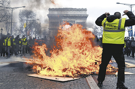 Manifestantes queman carteles frente al Arco del Triunfo en París.