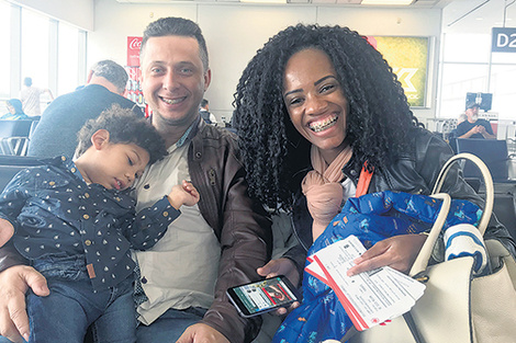 Thamaris muestra los pasajes del viaje a Vancouver. Wallace con Miguel en brazos.