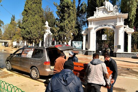 Los familiares retiran el féretro de un pariente de las puertas del cementerio de Cochabamba, donde no tienen cupo para enterrarlo.