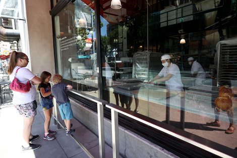 Una familia mira trabajar a empledos de una panadería en San Francisco, California.